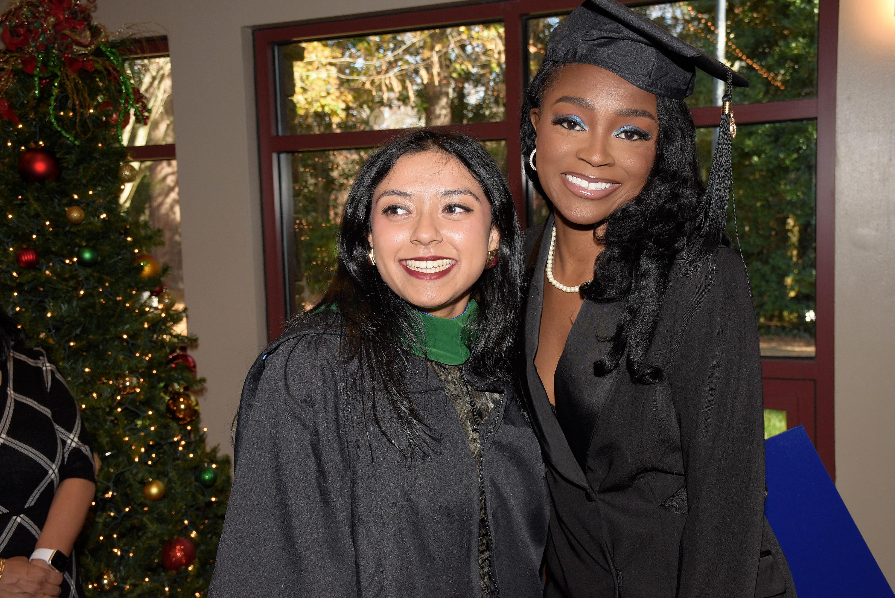two graduates standing together smiling