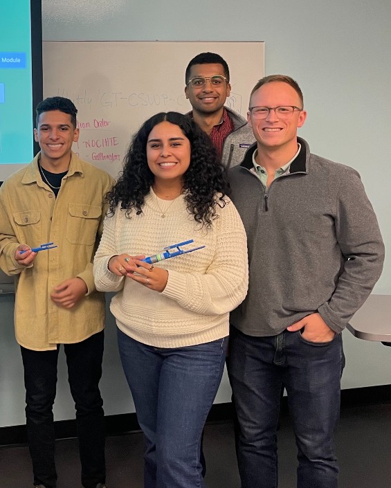 group of four people holding a medical device