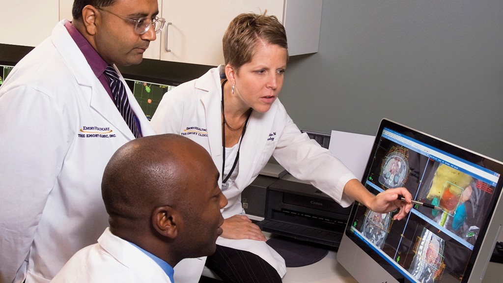 Group of faculty around a computer examining an image