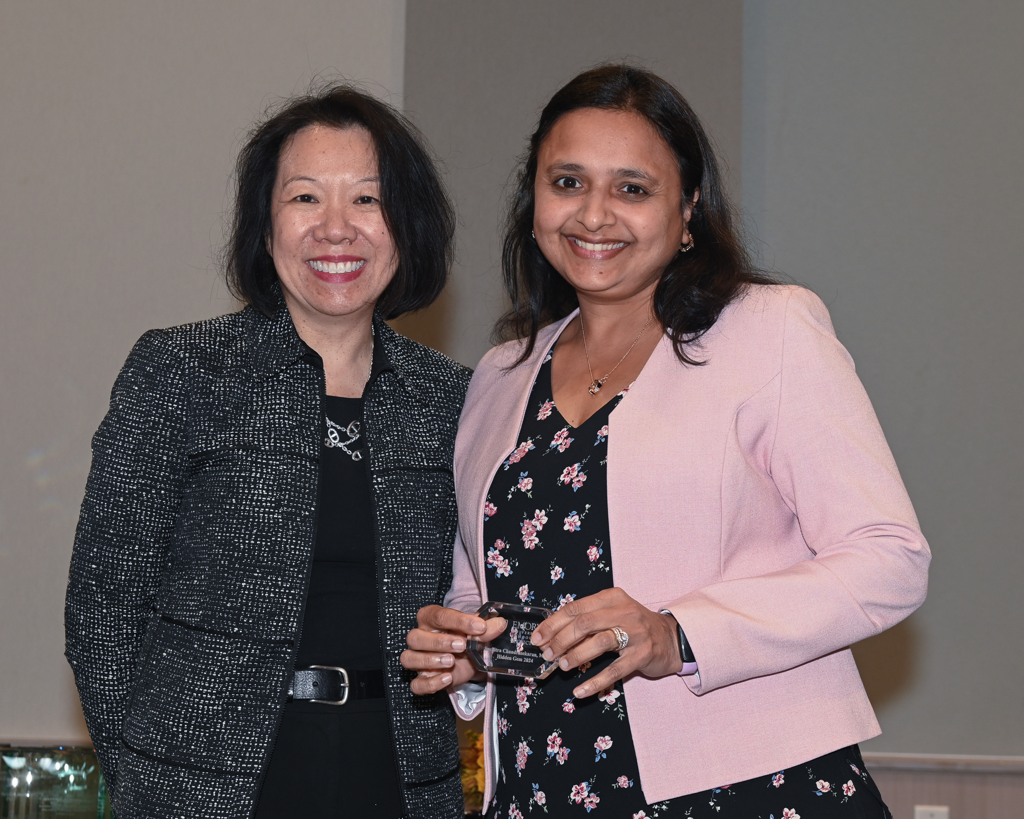 Faculty member accepts glass award on stage with dean