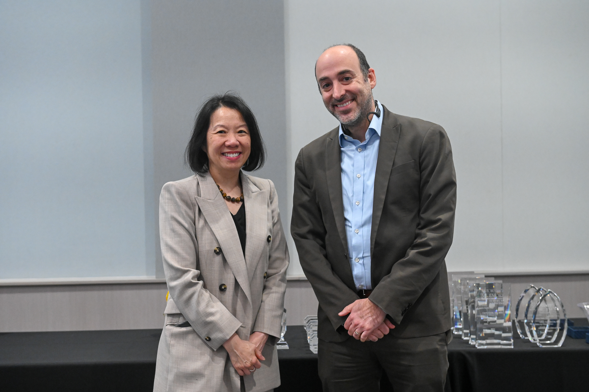 Man stand next to dean on stage. 