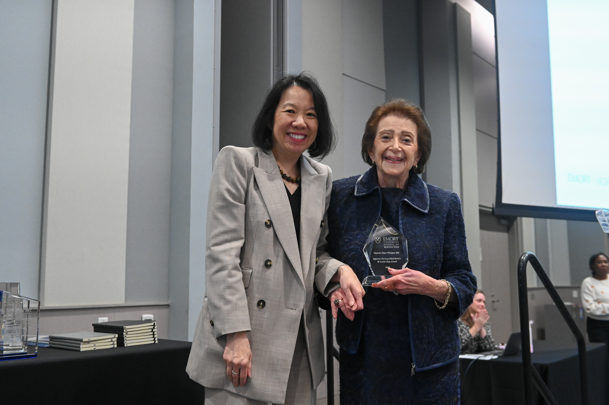 Faculty member accepts glass award on stage with dean