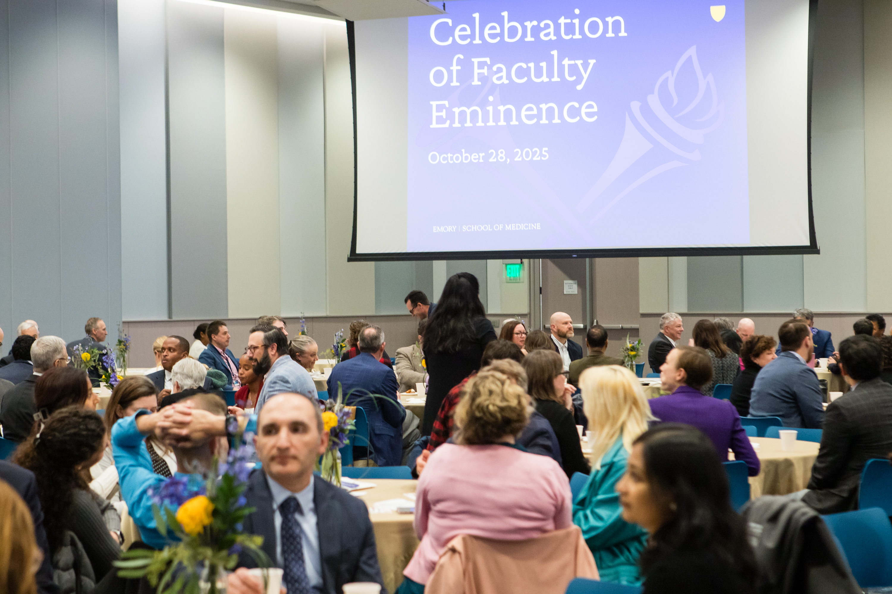 Faculty member accepts glass award on stage with dean