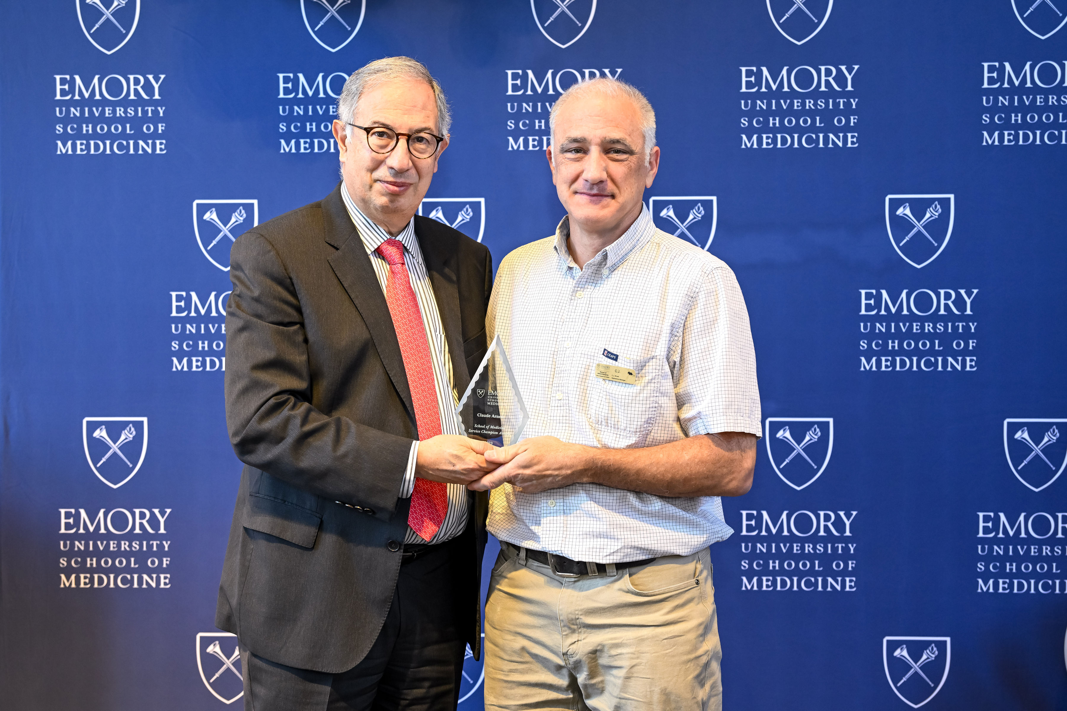 Claude Arnett accepting his award with interim Dean del Rio