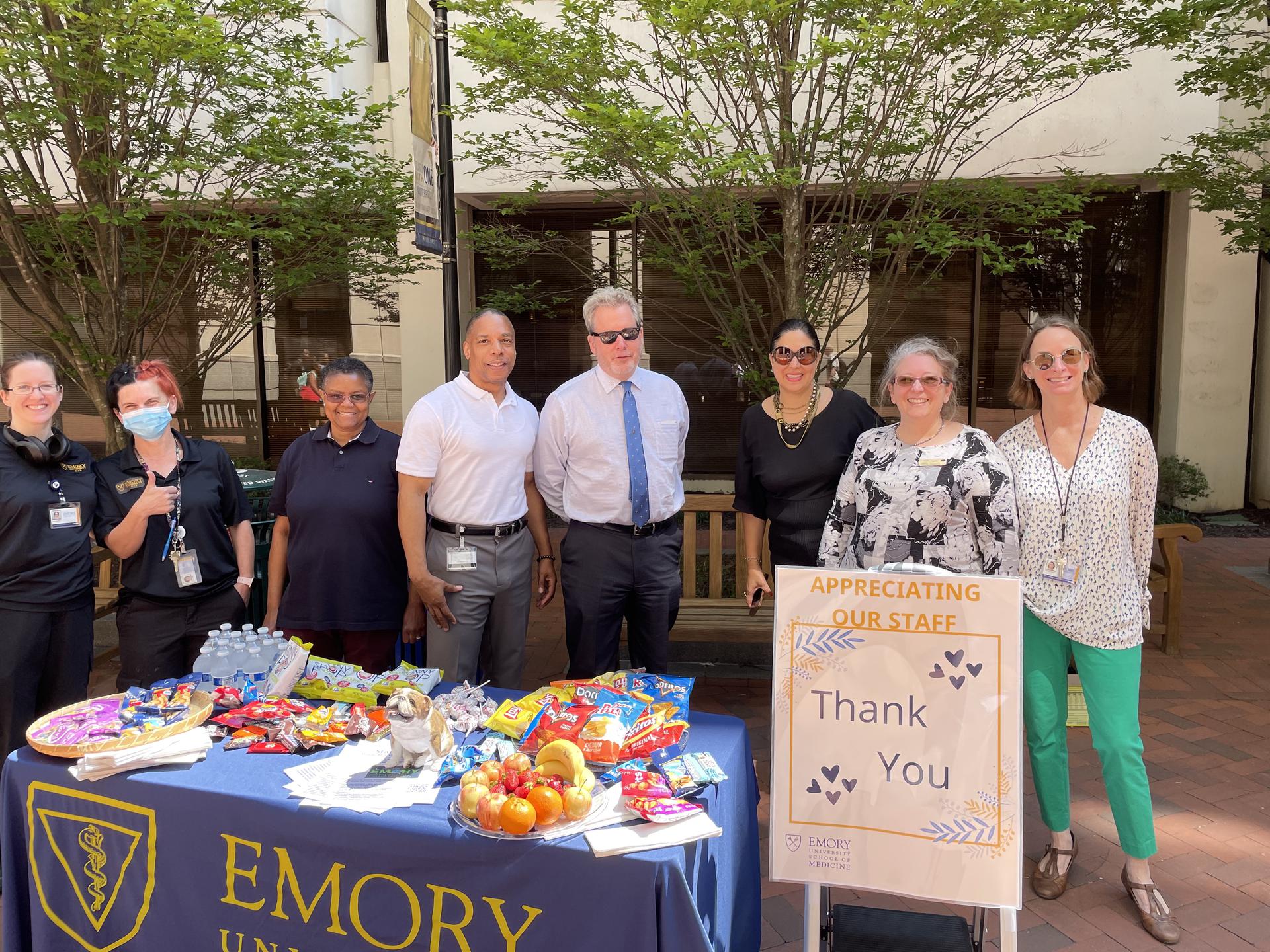 SOM staff gather around an appreciation table.