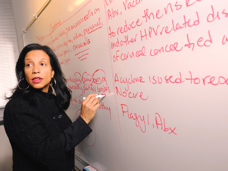 Faculty writing on white board