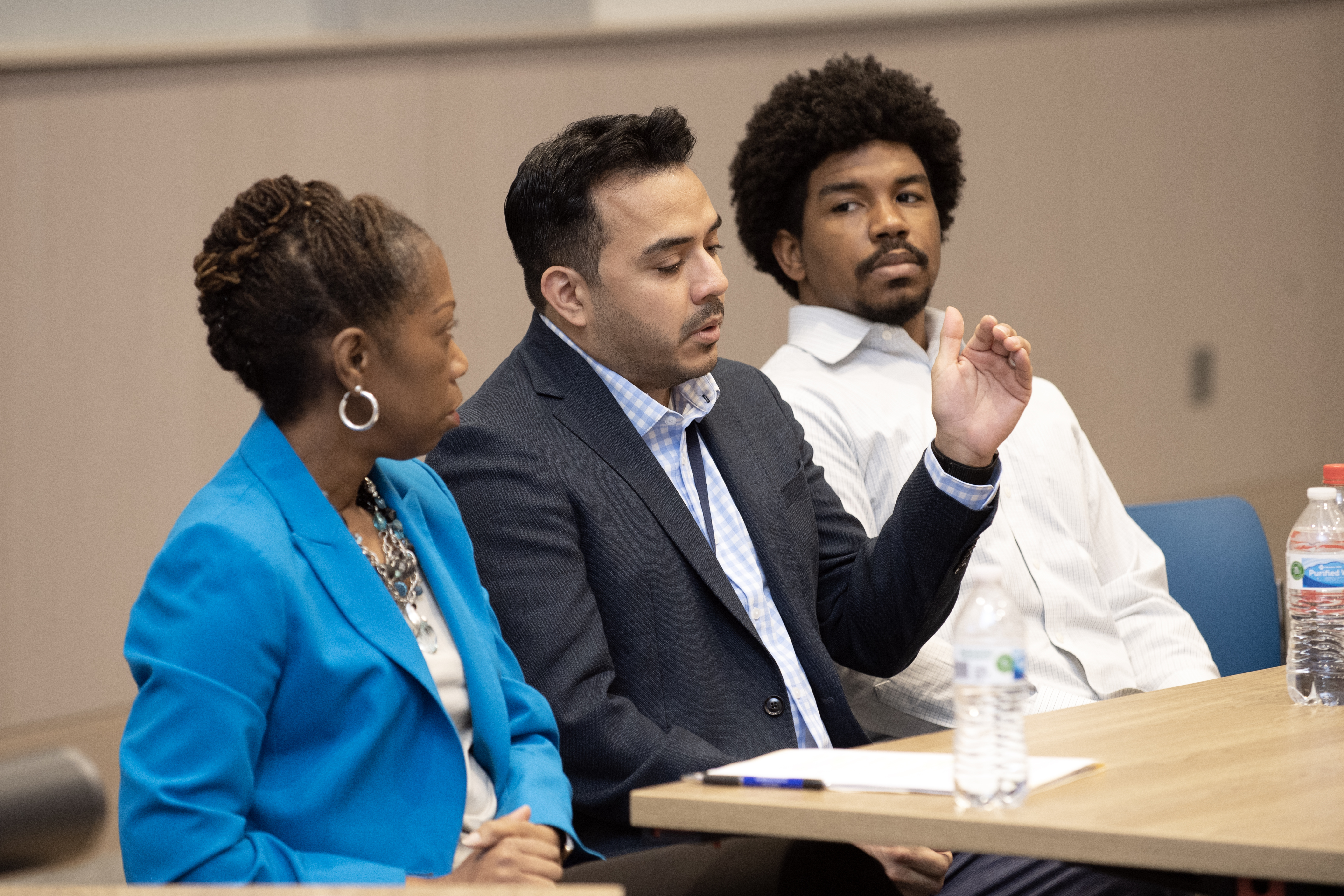 Three panelists sit answering talking during a session