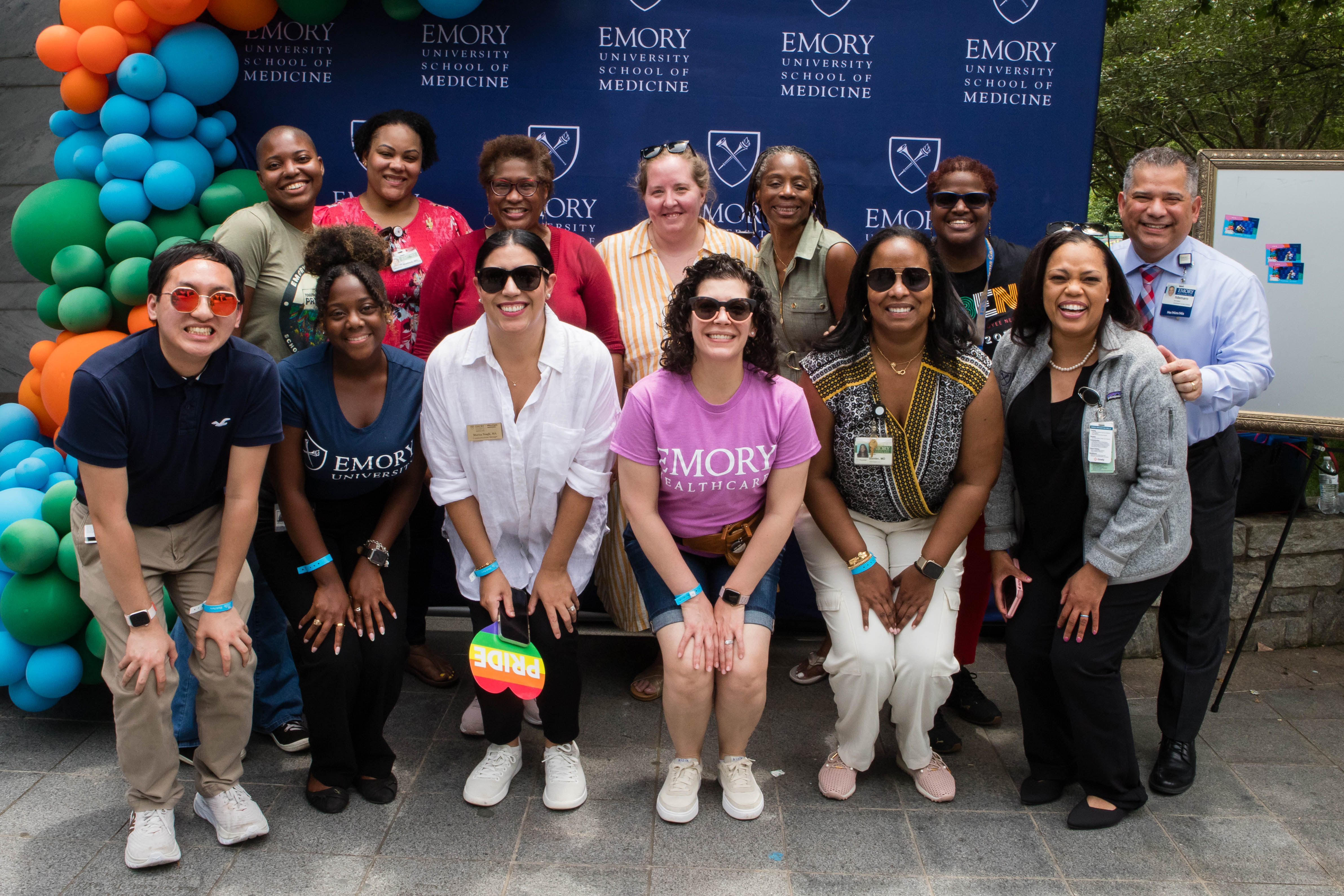 Group poses in front of step-and-repeat at Diversity and Inclusion Week block party.