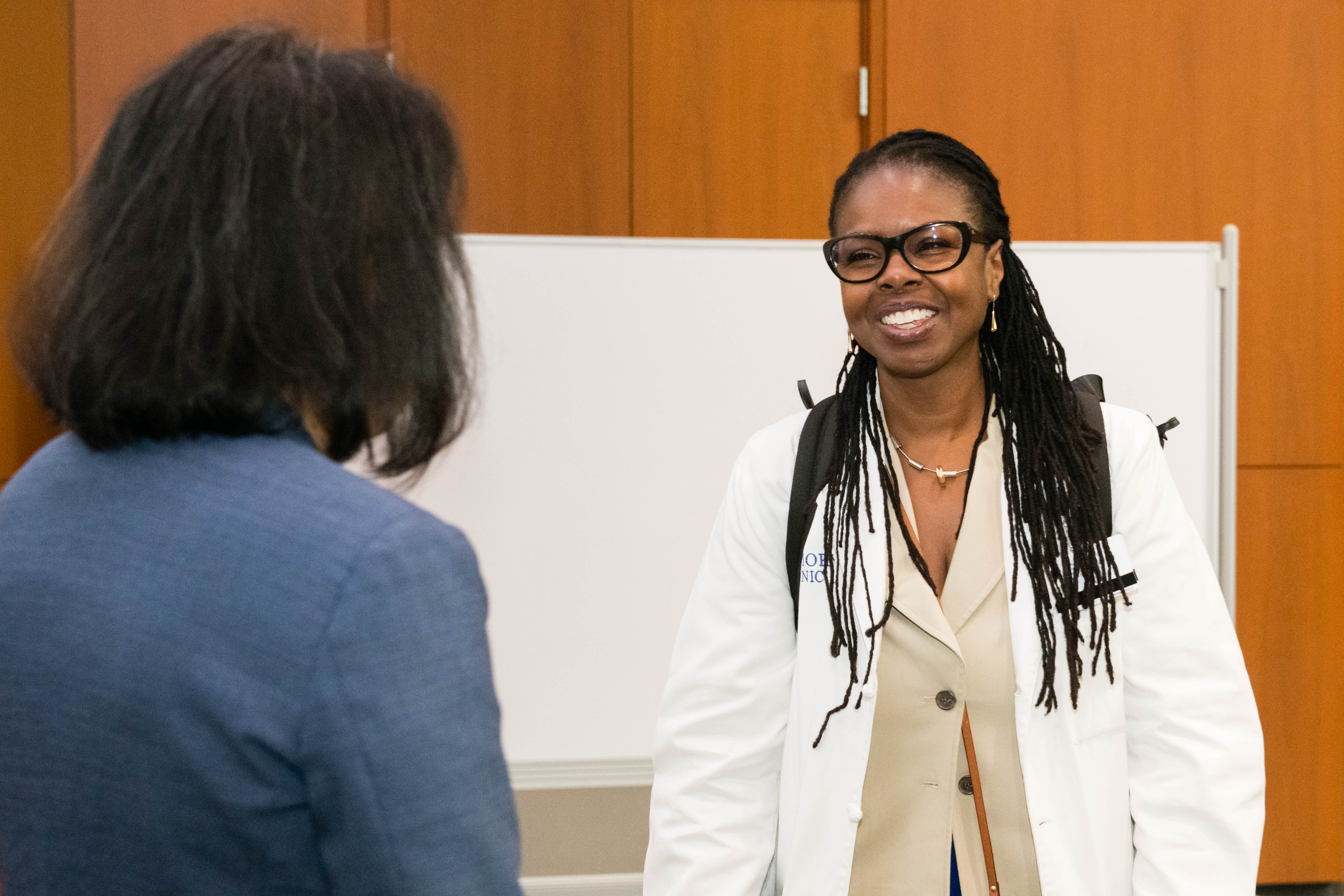 Two women talk with one woman smiling. 