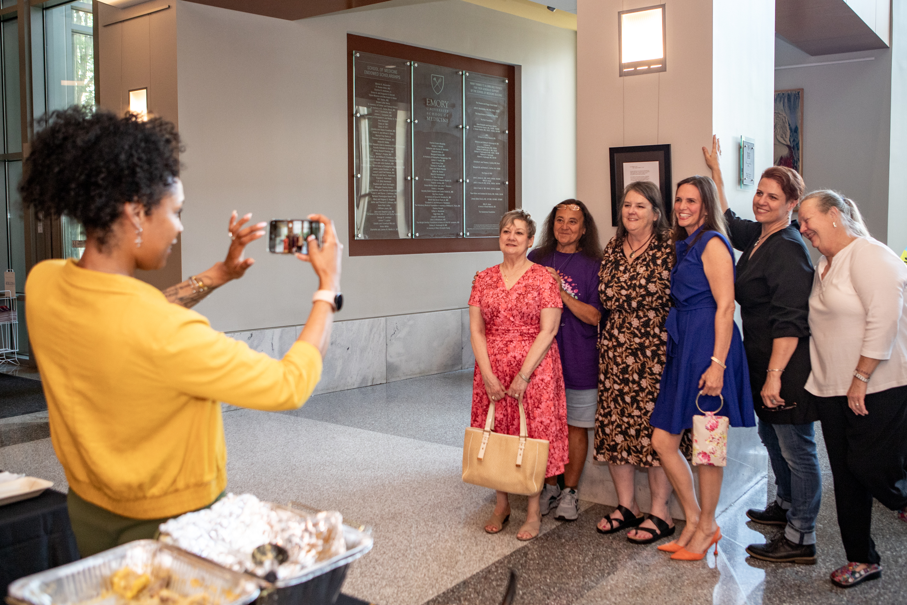 Woman takes a group photo of people at an event.