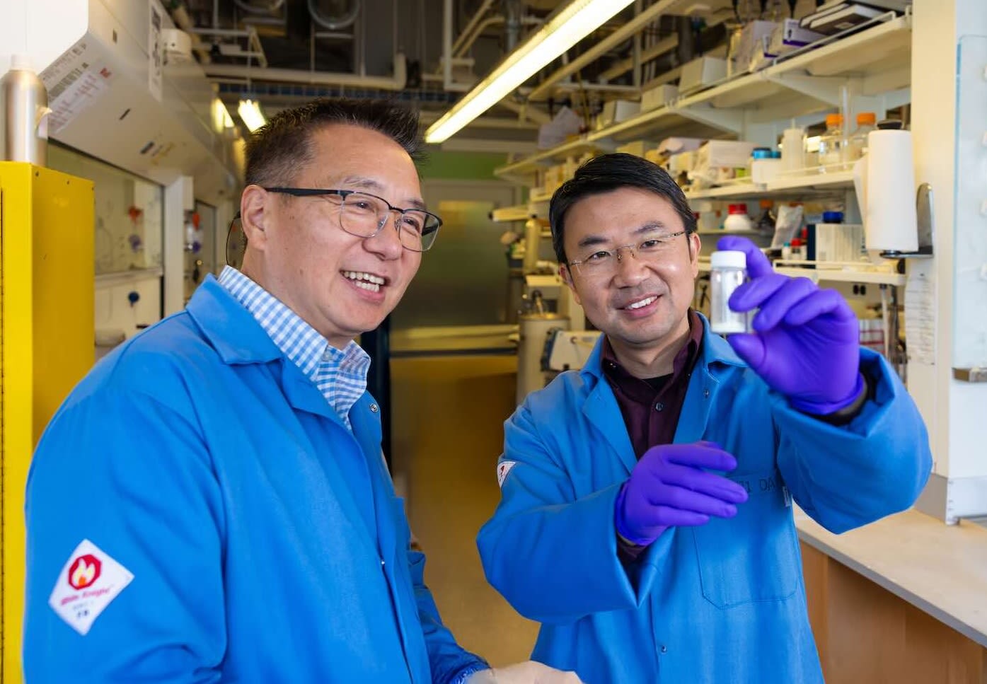 Two faculty look at test tube together.