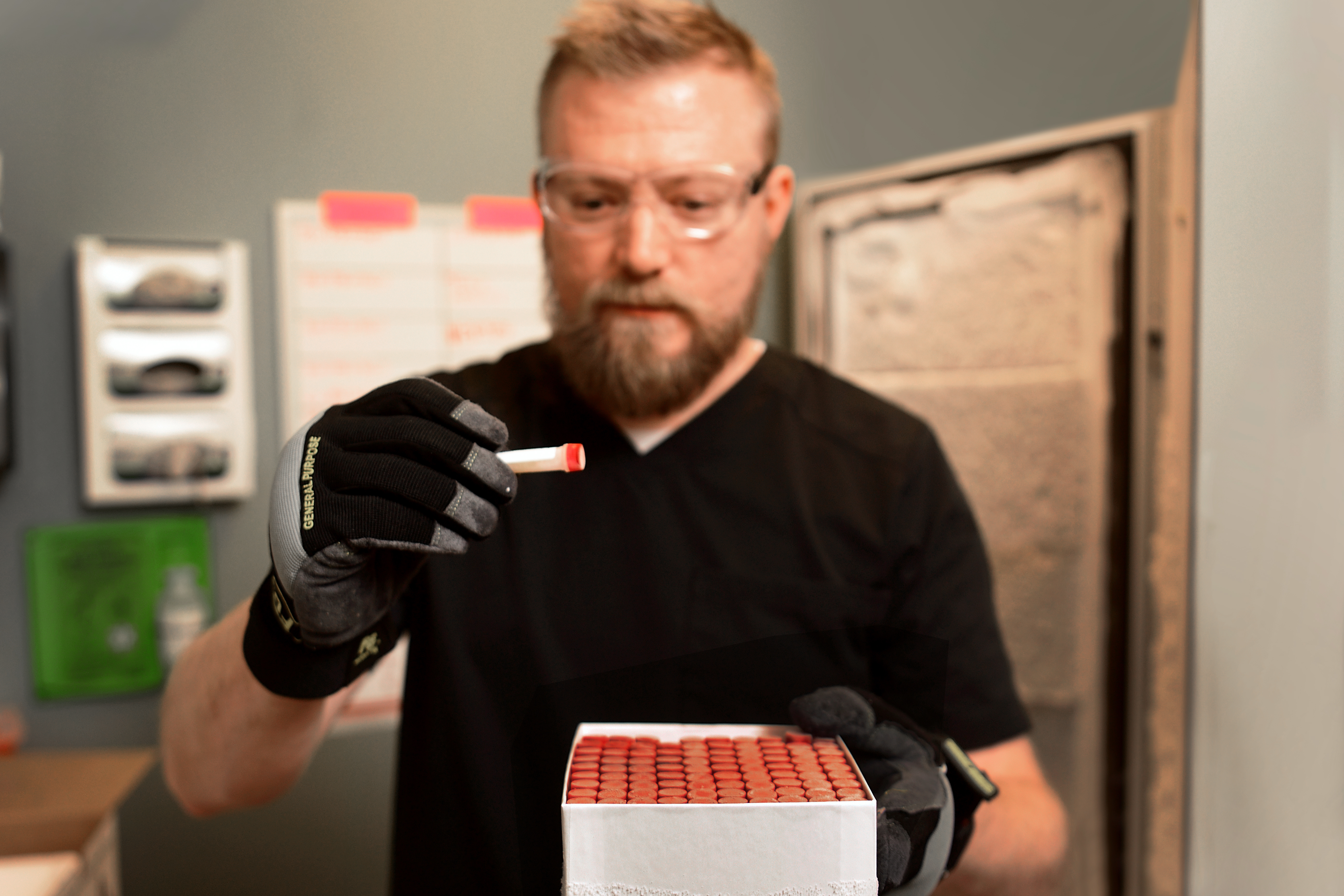 A man reviews something in a test tube. 