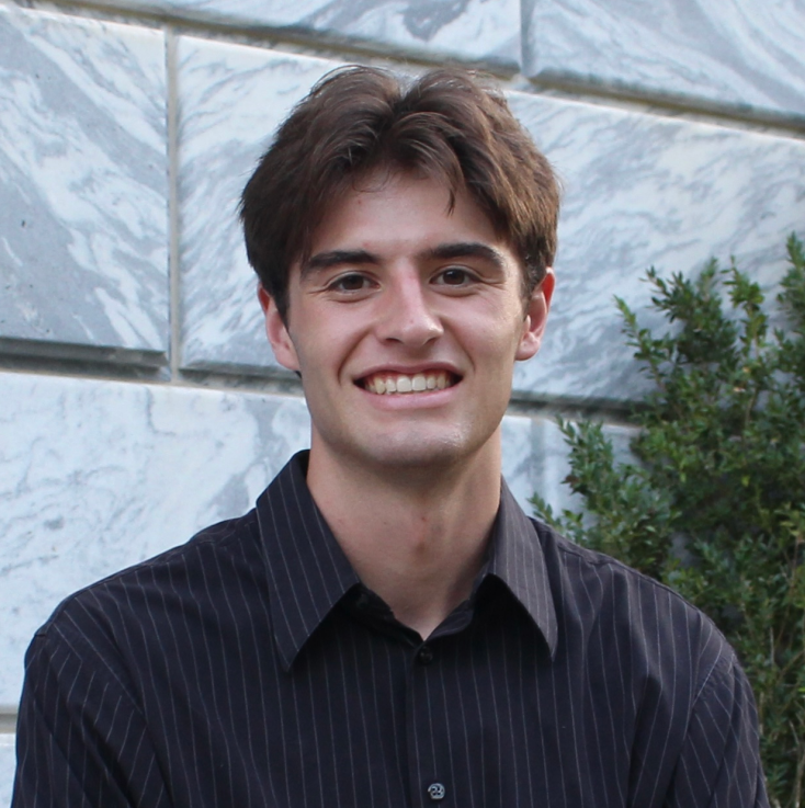 headshot of man in front of a building