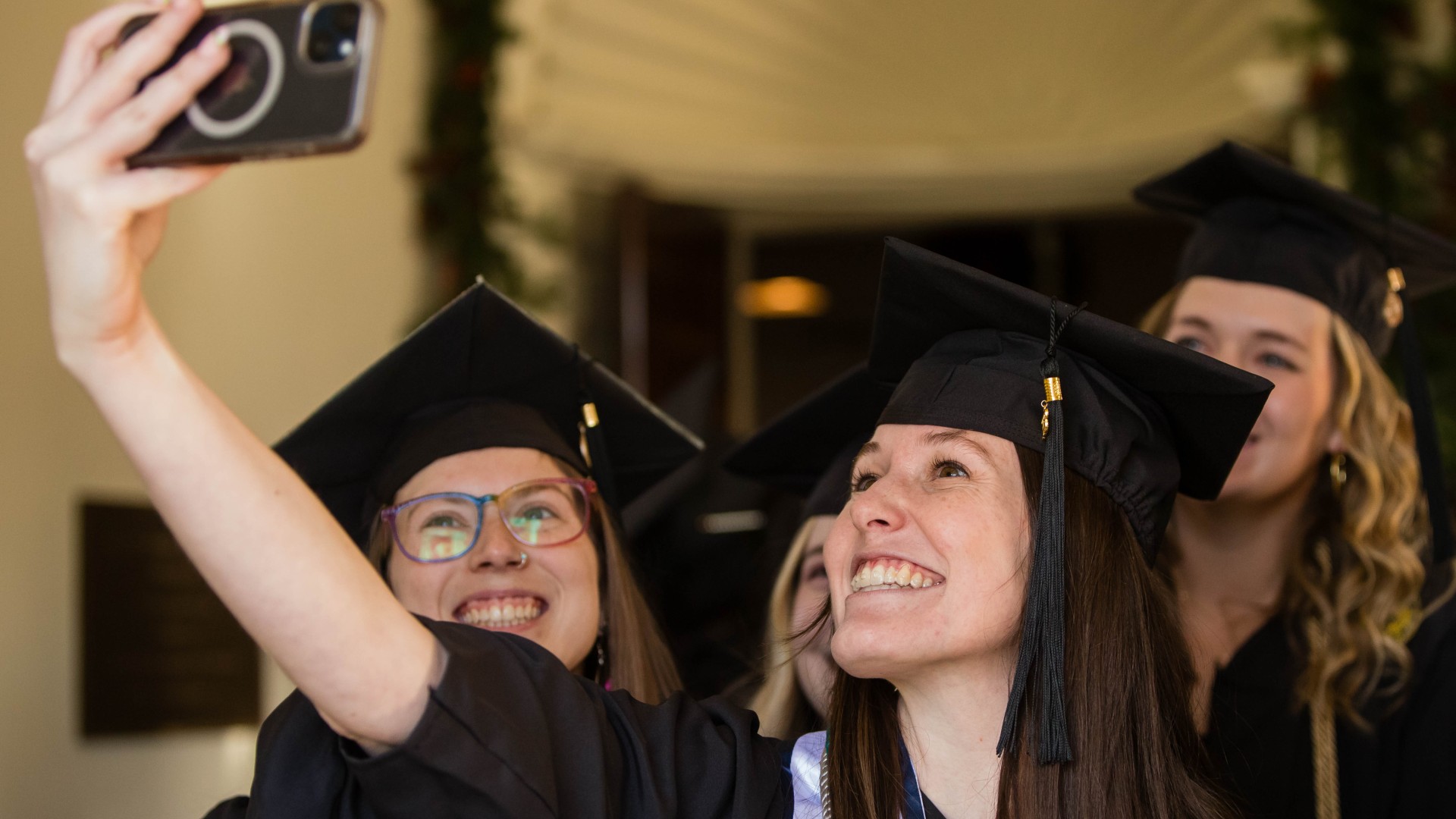 students in caps and gowns taking a selfie