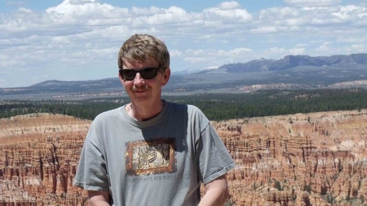 PA Tom Himelick standing in front of western US landscape with mountains