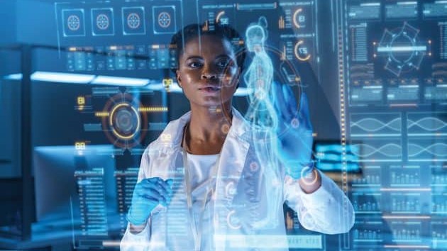 Black woman in white coat analyzing computer images