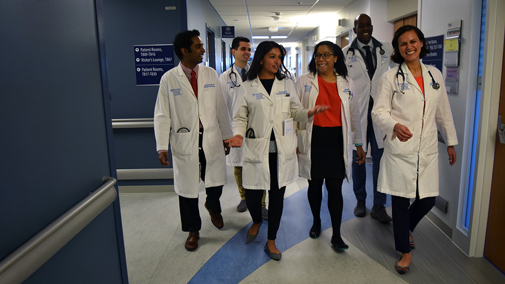 Medical oncology fellows walking down hall on inpatient floor.