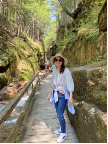 woman standing outside near stone wall