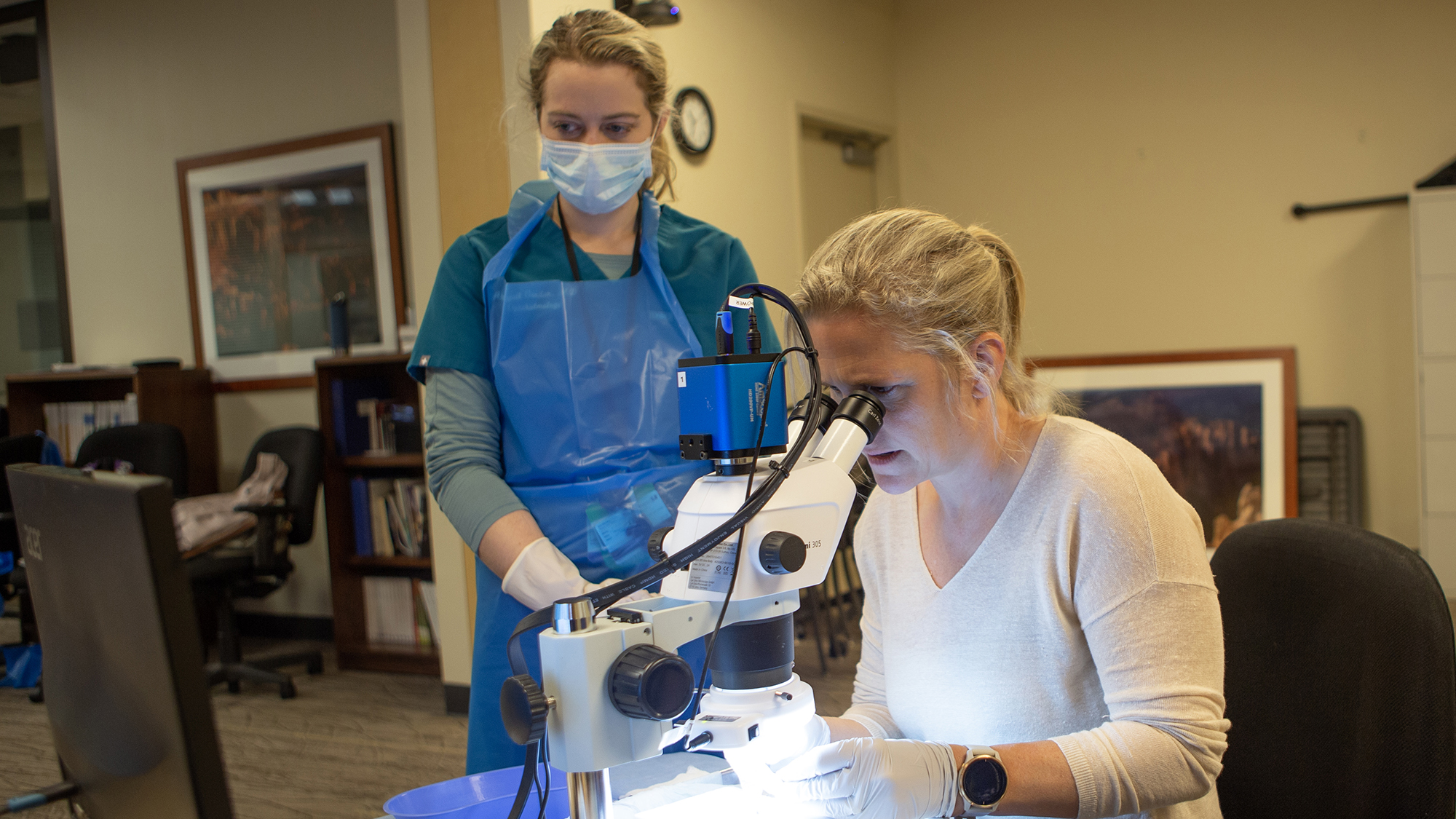 Dr. O'Banion leading a wetlab using a microscope and instructing a fourth-year resident