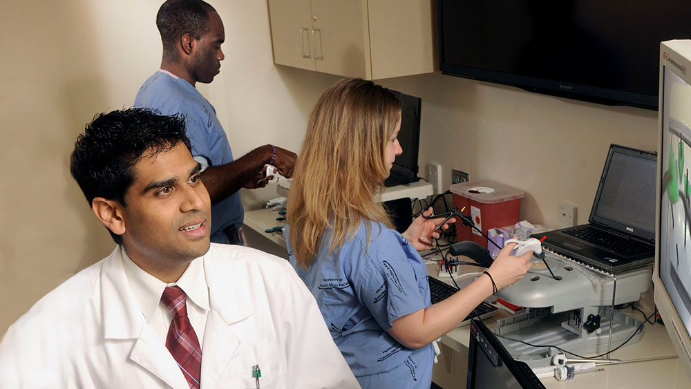 Faculty member and residents working in simulation lab.