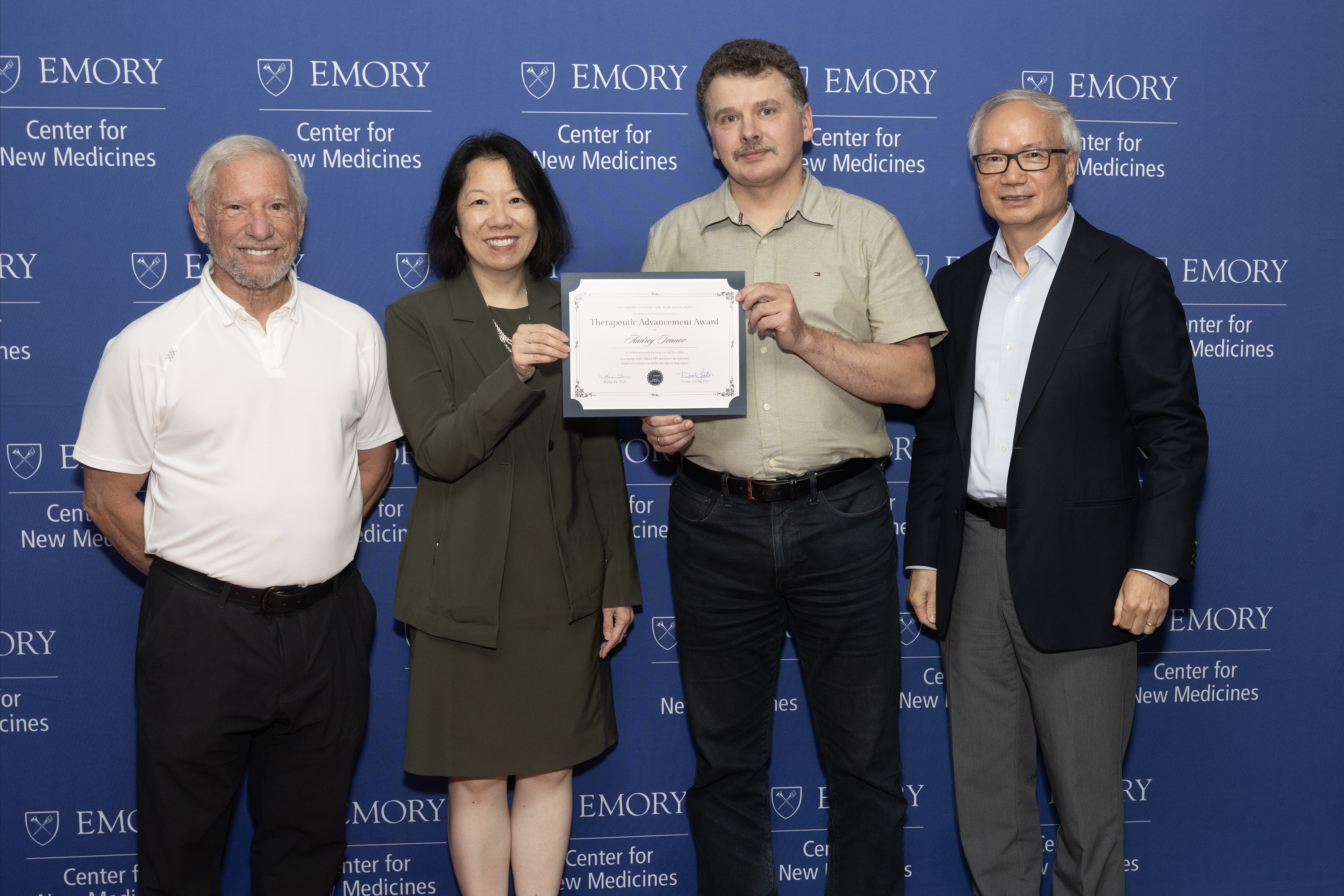 group photo with four people at award ceremony
