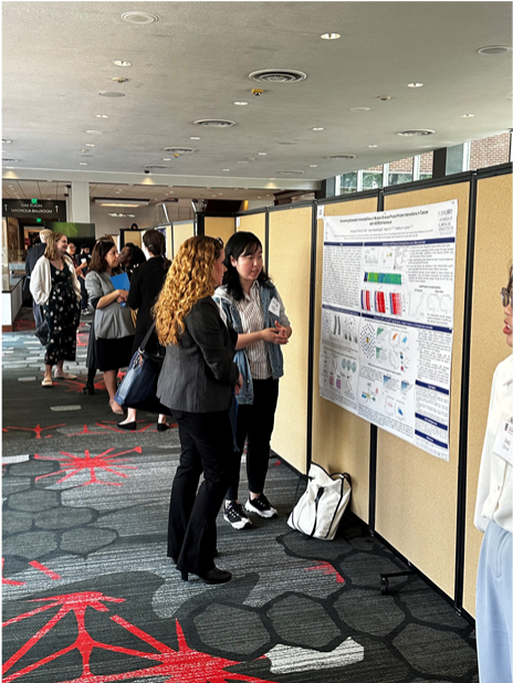 two women standing in front of poster presentation board