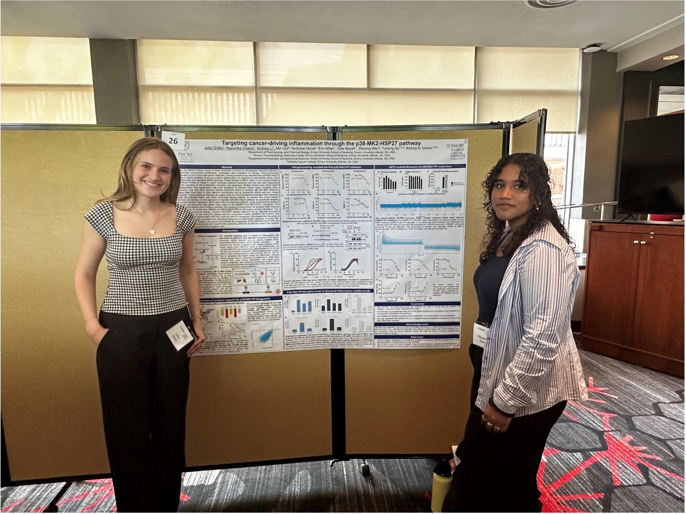 Two women standing in front of poster presentation