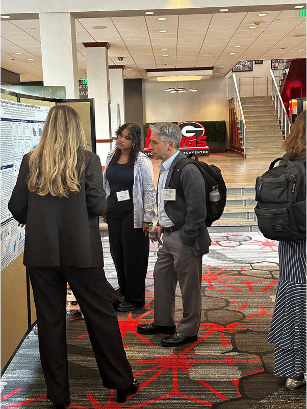 Three people standing at poster presentation