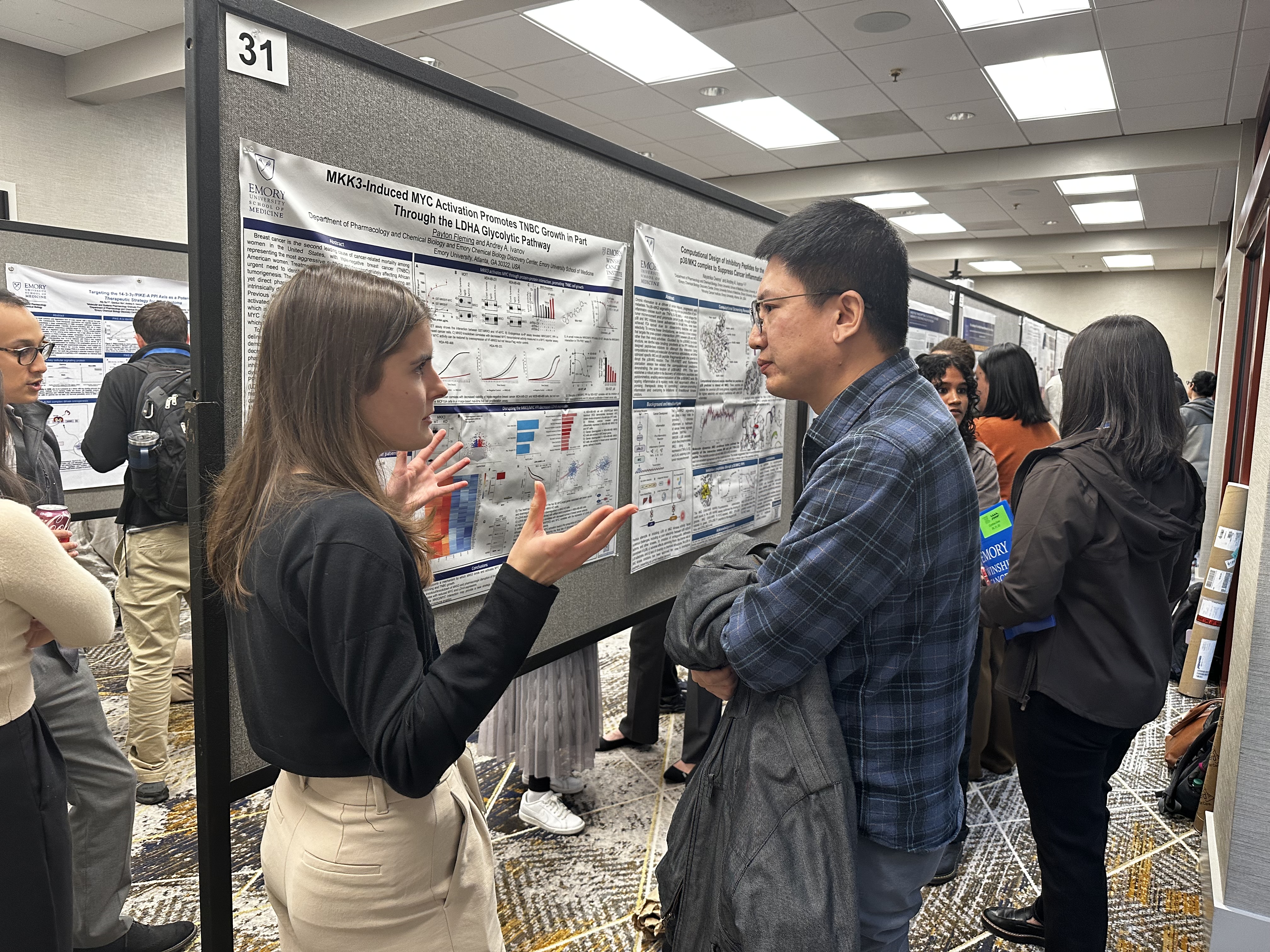 group of people standing at poster presentation board