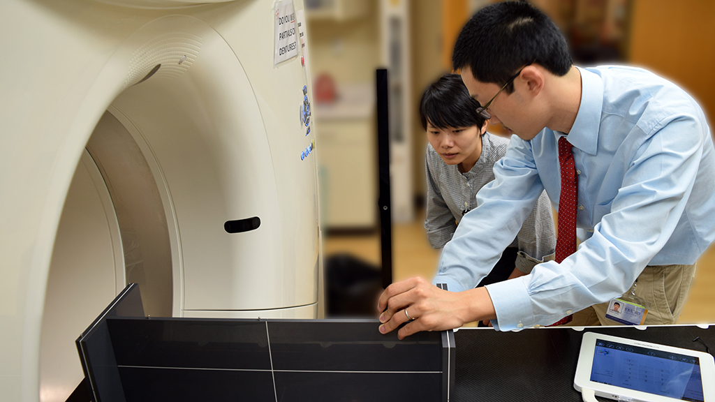 Image of medical physics residents in treatment room.