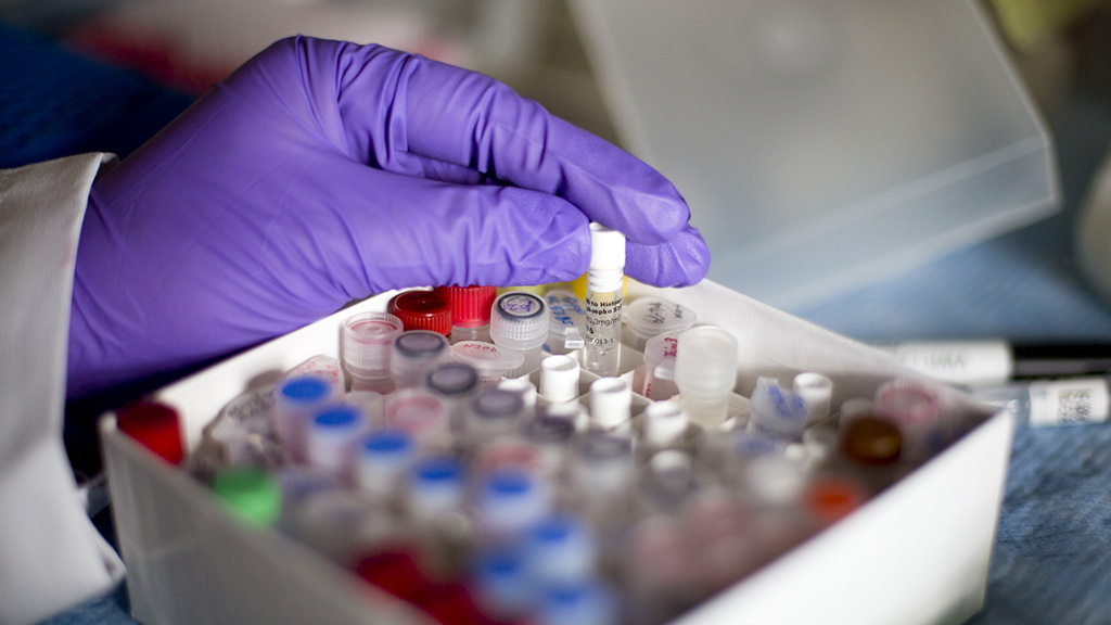 Research technician pulling out vial.