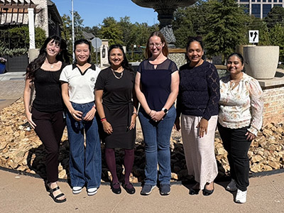 Kesarwala lab team members outside in front of a fountain.