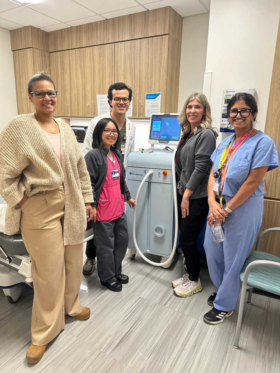 five smiling people flanking cryoablation machine
