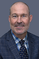 smiling man with light skin and closely cropped hair with light beard and mustache