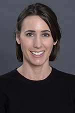 smiling woman with medium complexion and chin length brown hair and wearing a dark shirt