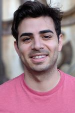 smiling man with short dark hair wearing an azalea pink shirt