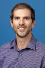 smiling man wearing patterned shirt