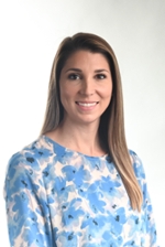 smiling person wearing a dress with blue flowers printed on a white background