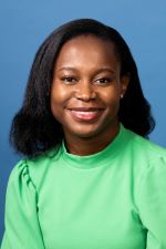 Dr. Ndibe smiling in green top with dark hair and skin