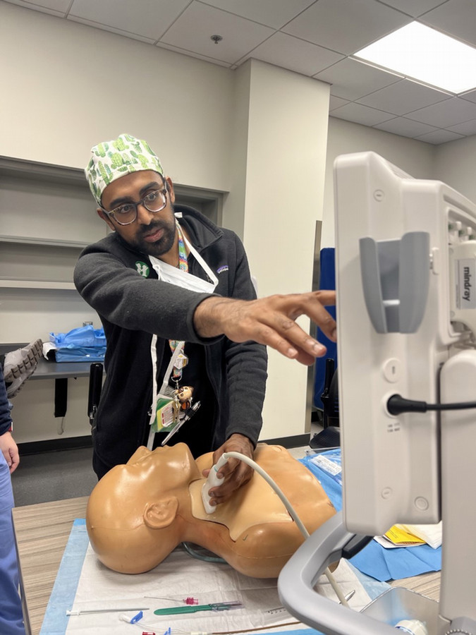 person showing someone how to do an ultrasound of the neck