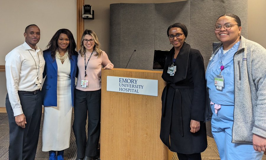 people standing together by a podium that says Emory Healthcare