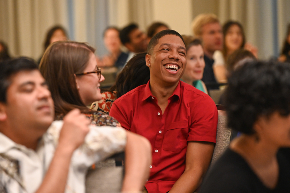 person laughing while others around them smile