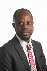 serious person wearing a dark suit jacket over a white shirt and red and white tie