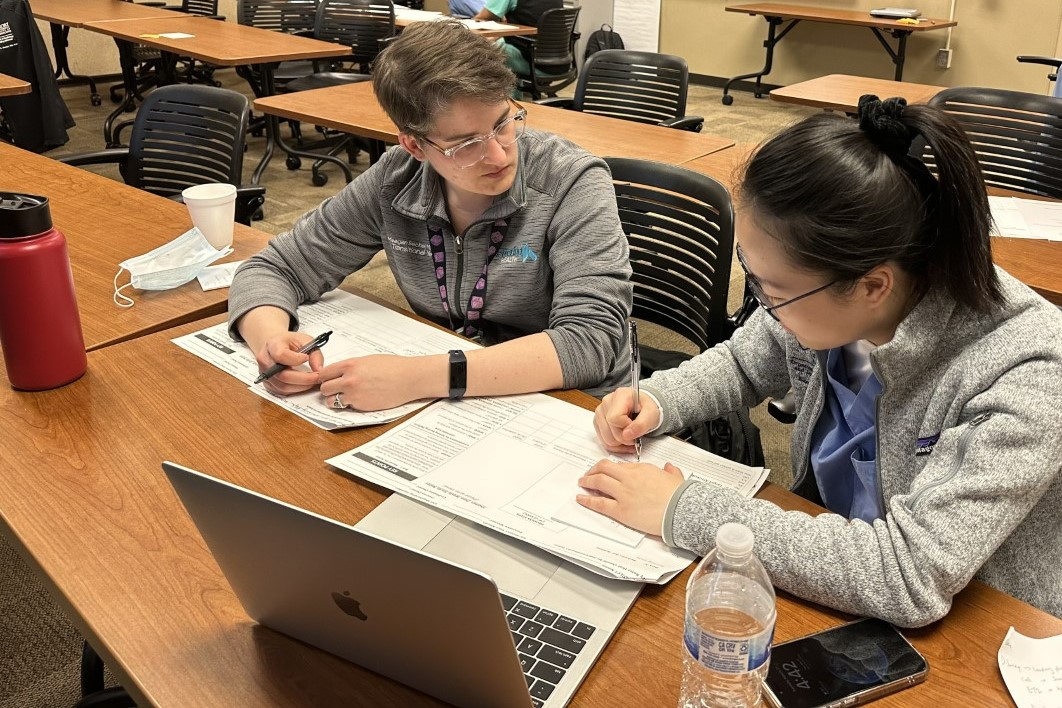 two people talking while working on writing something