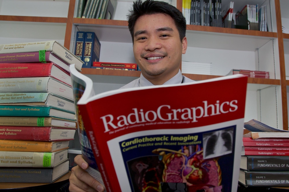 smiling man reading clinical journal