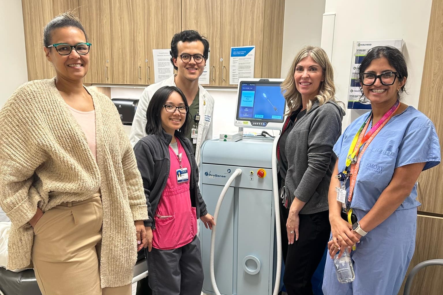 five people smiling and standing around a cryoablation machine