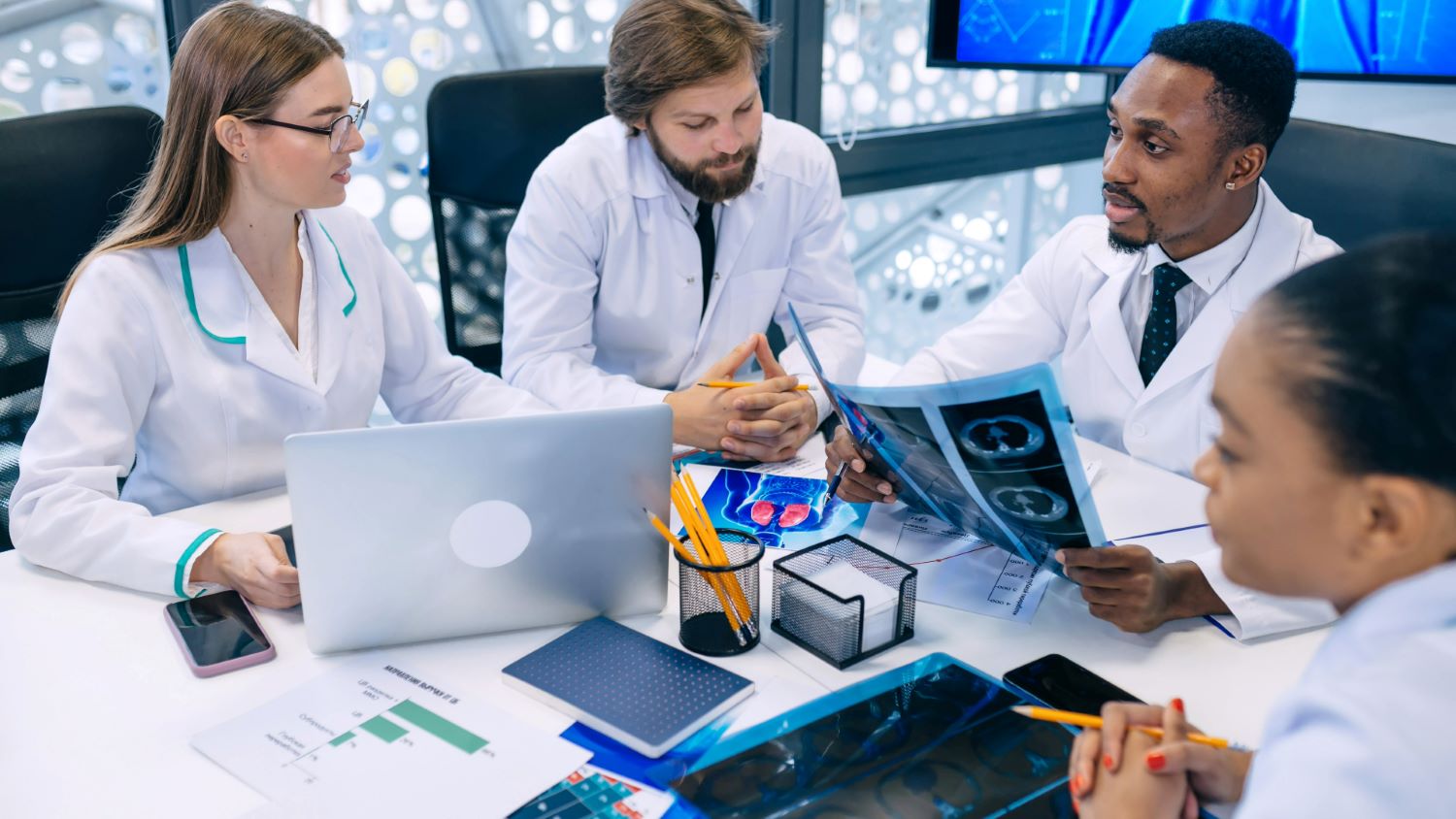 four doctors looking at radiology films