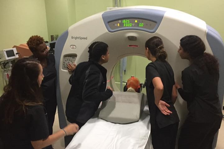 group of students looking at placement of person in ct machine