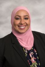 smililng person wearing pink headscarf an a black top