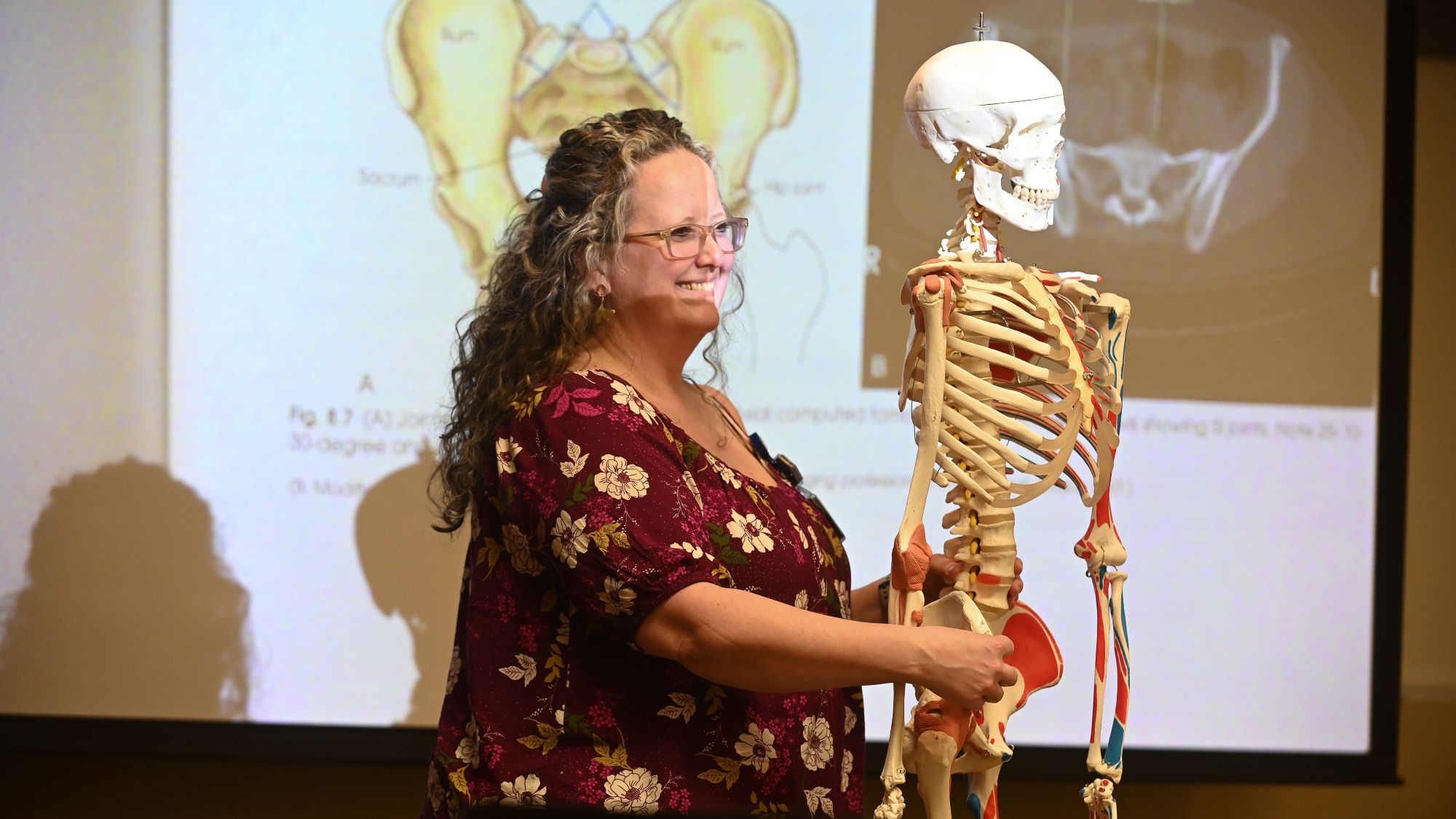 woman standing beside skeleton with red and blue lines on skeleton